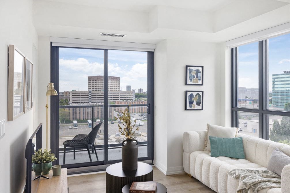a living room with a couch and a balcony overlooking a city