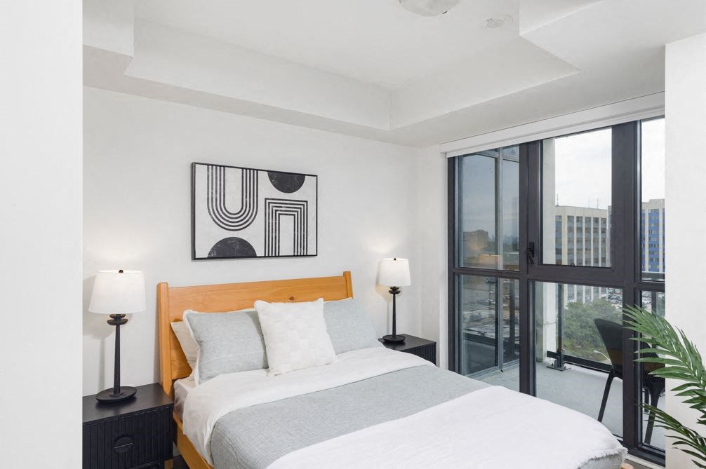 a bedroom with a bed and a large window