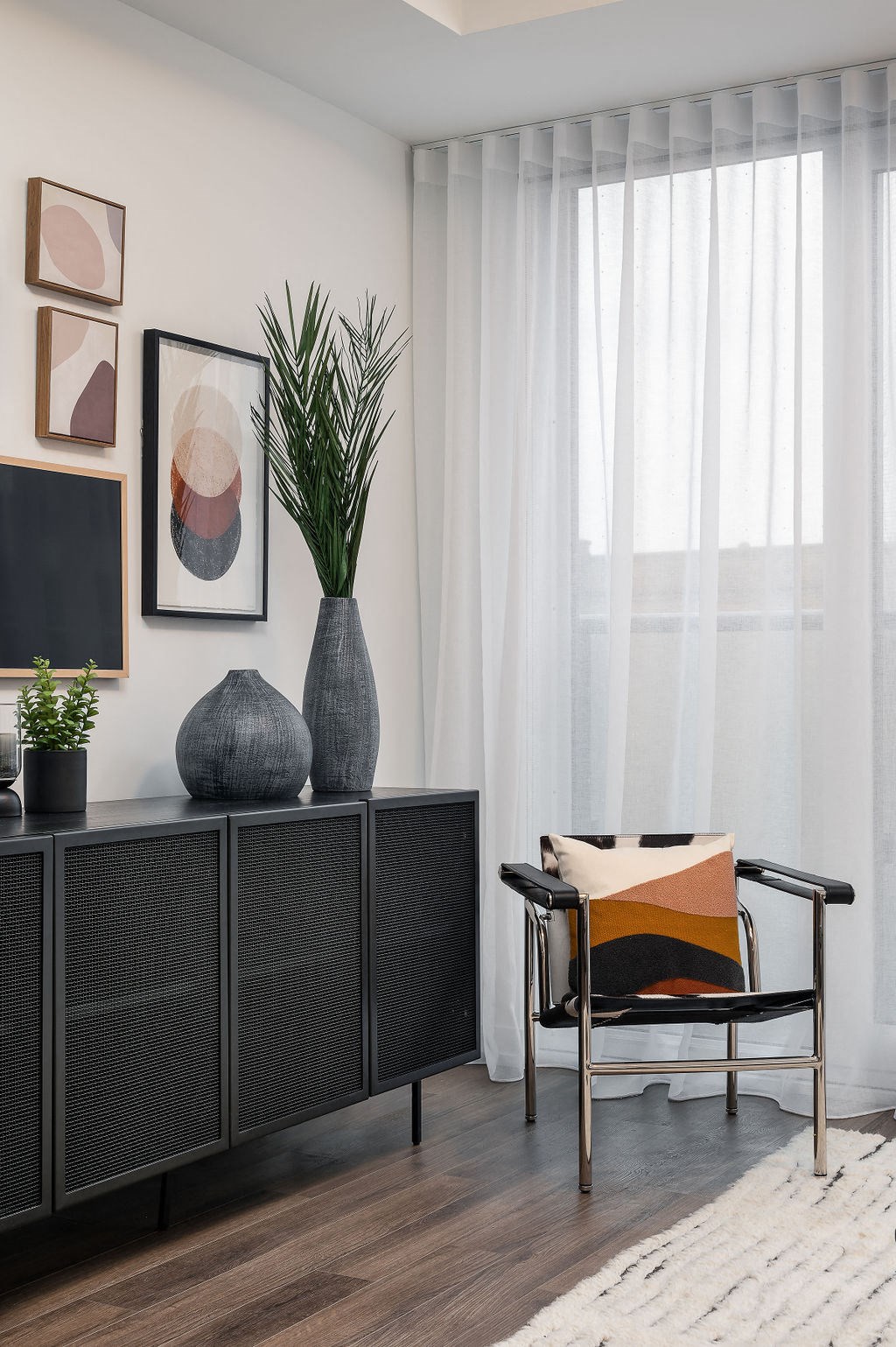 a corner of a living room with a chair and a vase