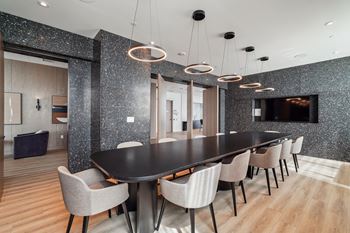 a dining room with a long black table and chairs