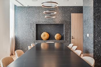 a dining room with a long table and two spheres on the wall