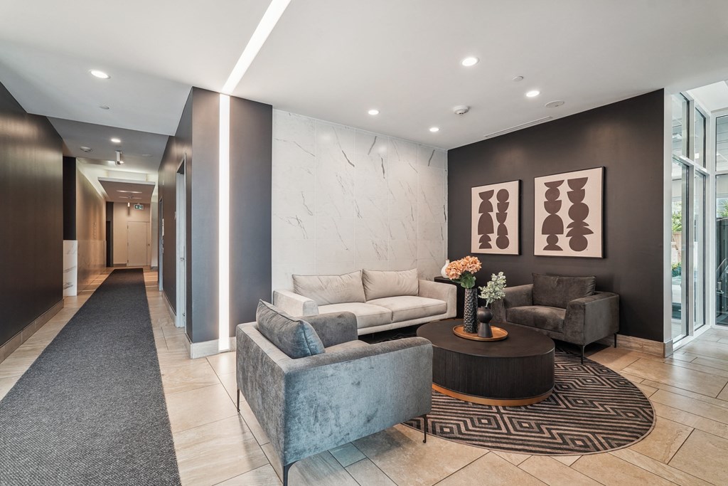 a lobby with couches and chairs and a rug