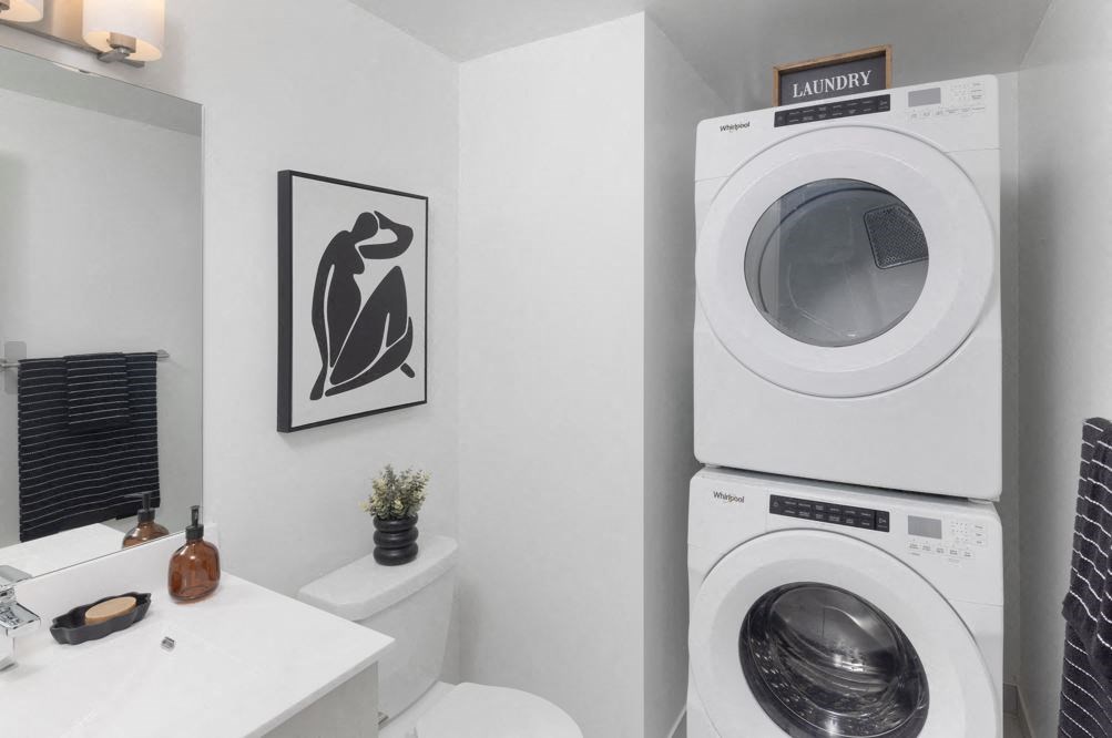 a bathroom with a washing machine and a sink and a geometric wallpaper