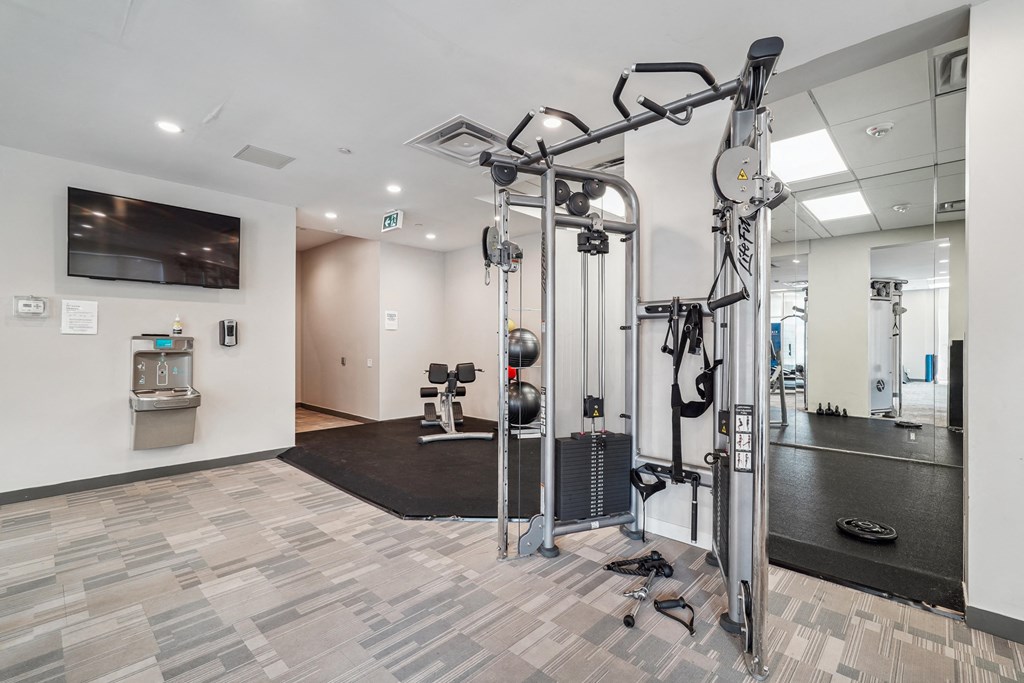a gym with weights and a tv in the corner of a room