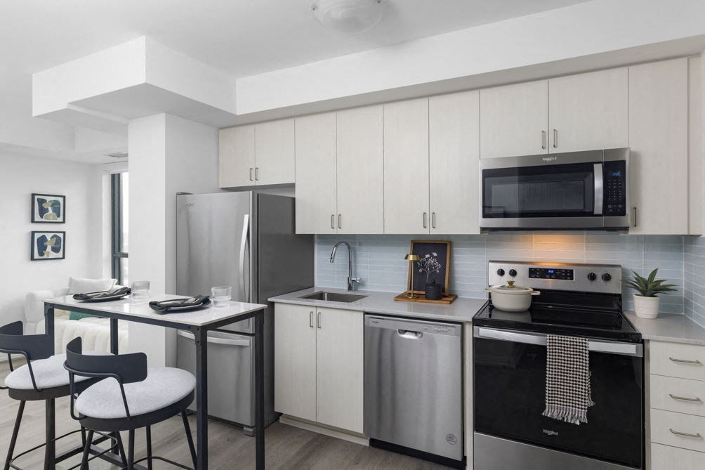 a kitchen with stainless steel appliances and white cabinets
