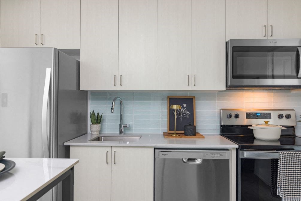a kitchen with white cabinets and stainless steel appliances