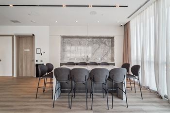 a dining room with a table and chairs and a painting on the wall