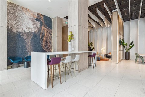 A white reception desk with a white counter and a white chair with a purple back.