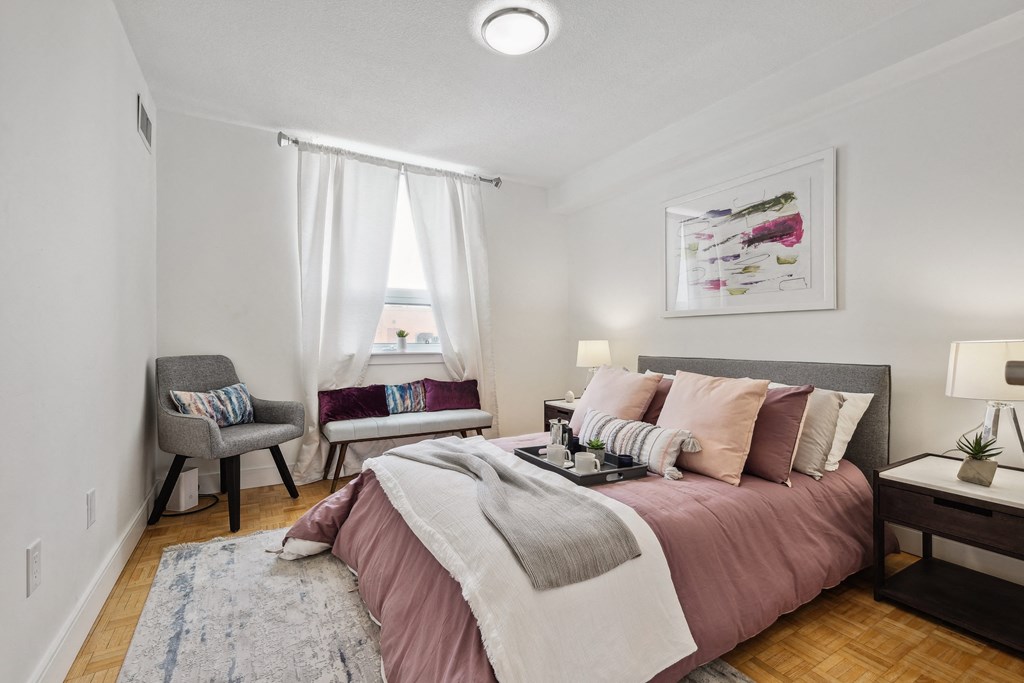 a bedroom with a bed and two chairs and a window