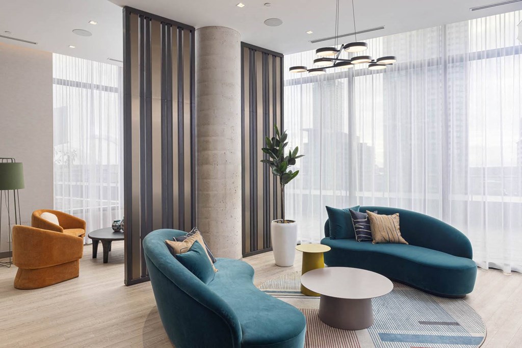 a living room with blue furniture and large windows