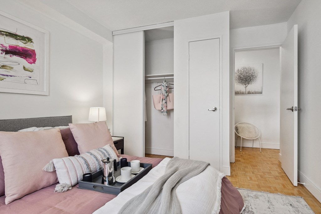a bedroom with a bed with pink pillows and a tray