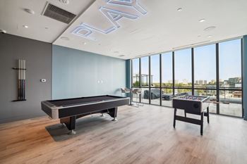a game room with a pool table and a view of the city