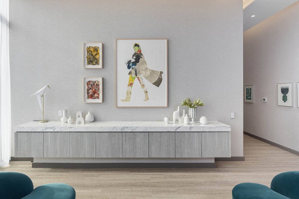 a reception area with a white table and a painting on the wall