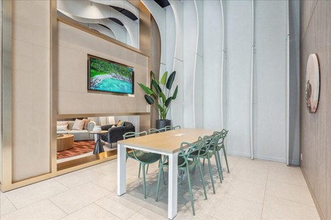 A modern living room with a television and a dining table.