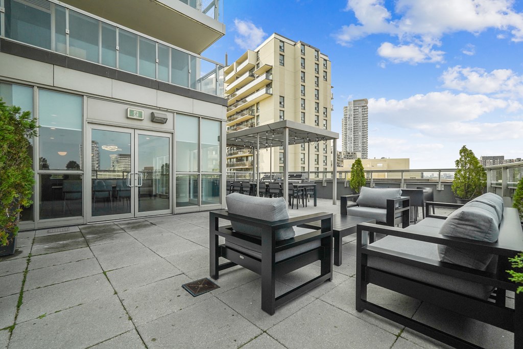 a large patio with chairs and tables and a building in the background