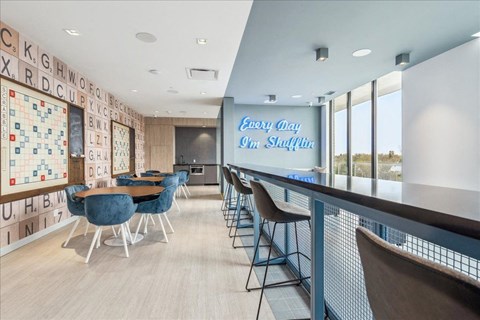 A room with a long table and chairs with a sign that says "Every Day 9am Shuffle".