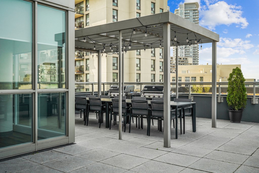 a communal terrace with tables and chairs under a canopy