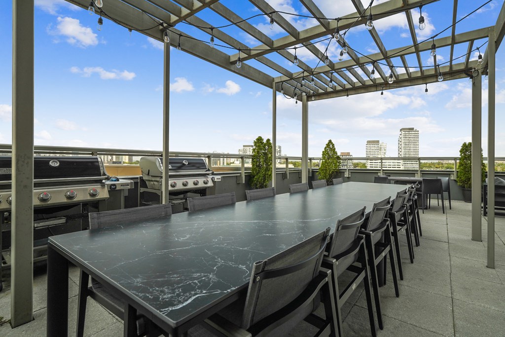 a long communal table on the roof of a building with barbecue grills