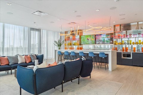 A modern living room with a bar area and a kitchenette.