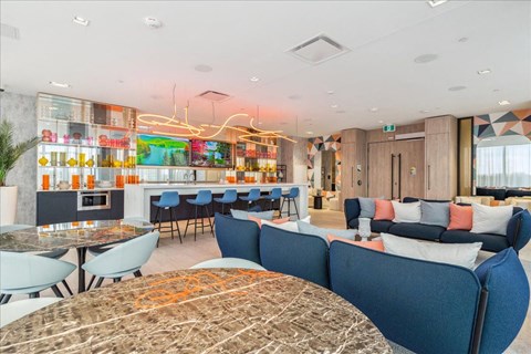 A modern living room with a blue sofa and a glass table.
