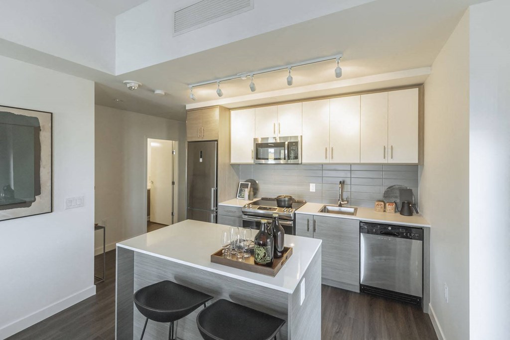 a kitchen with a white counter top and a sink