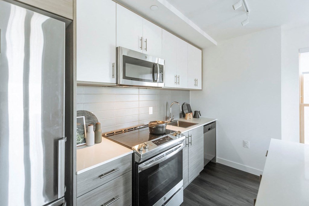 a kitchen with white cabinets and stainless steel appliances