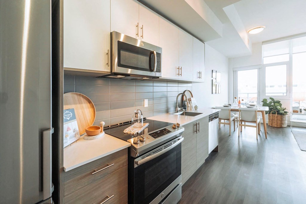 a kitchen with white cabinets and a stove and a microwave