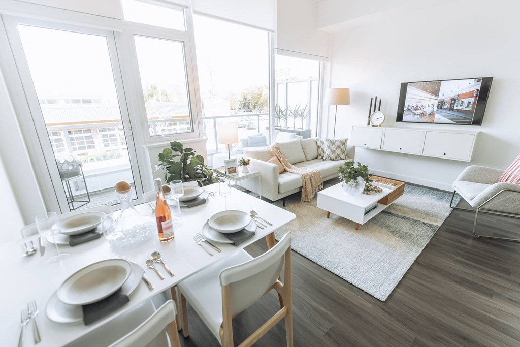 a living room and dining room with a table and chairs