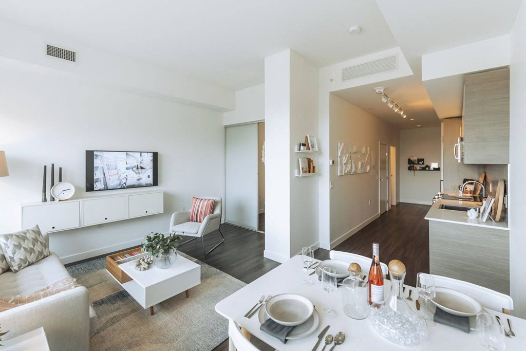 a living room and dining room with a table and chairs