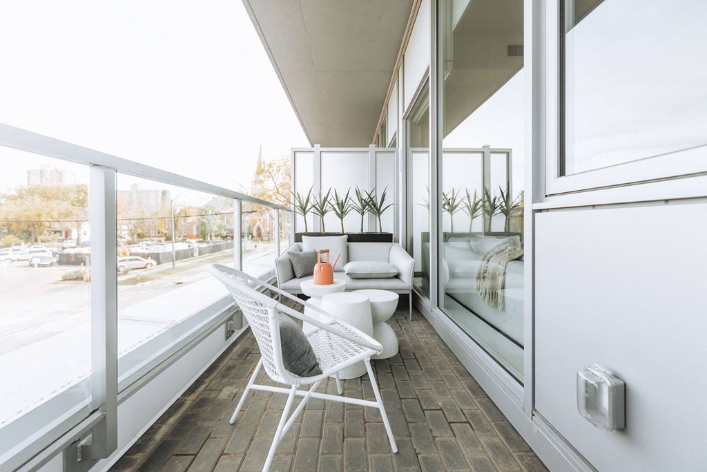 a balcony with white furniture and large windows