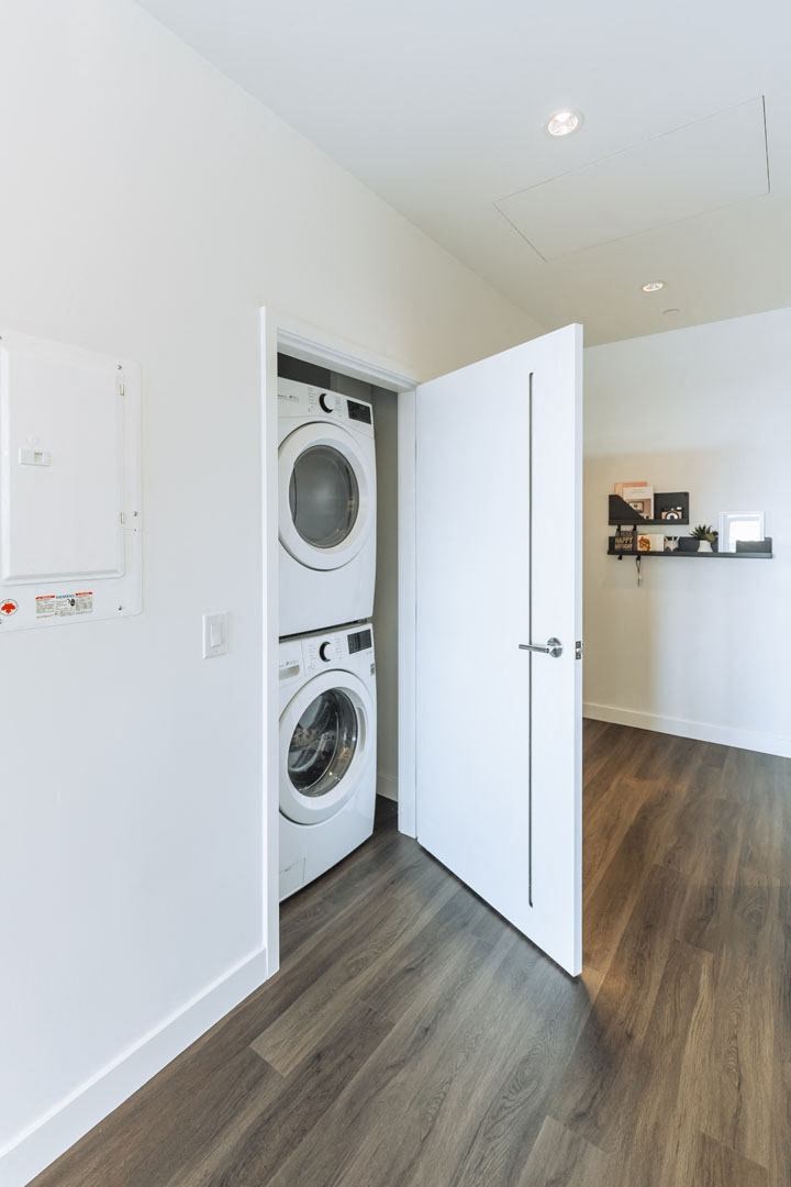 a washer and dryer in a white room with a door