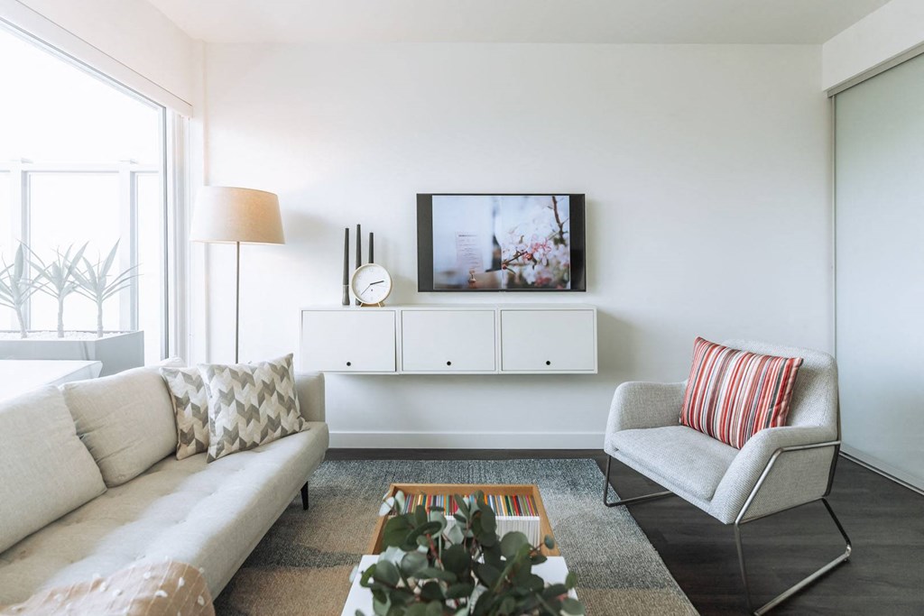 a living room with a couch and a chair and a television