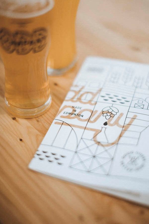 a piece of paper on a table next to a glass of beer