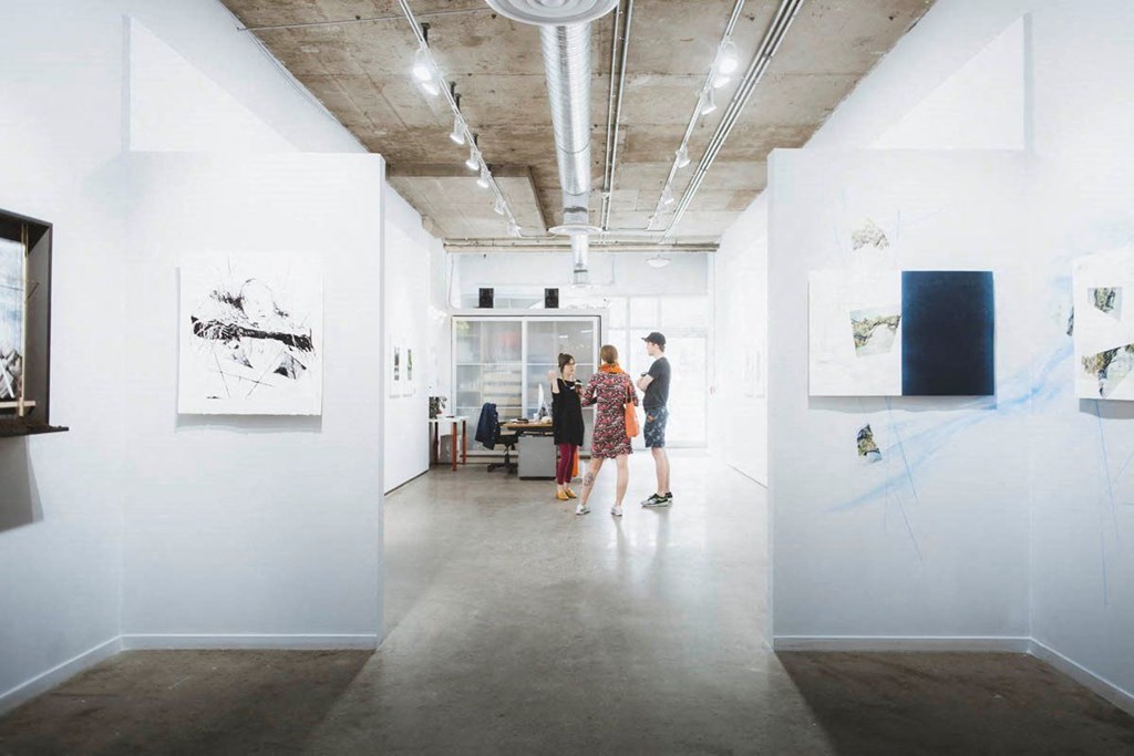 a group of people walking through an art gallery