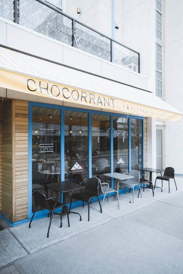 the outside of a restaurant with tables and chairs