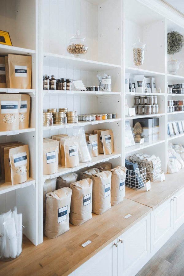 a white pantry filled with boxes and containers on shelves
