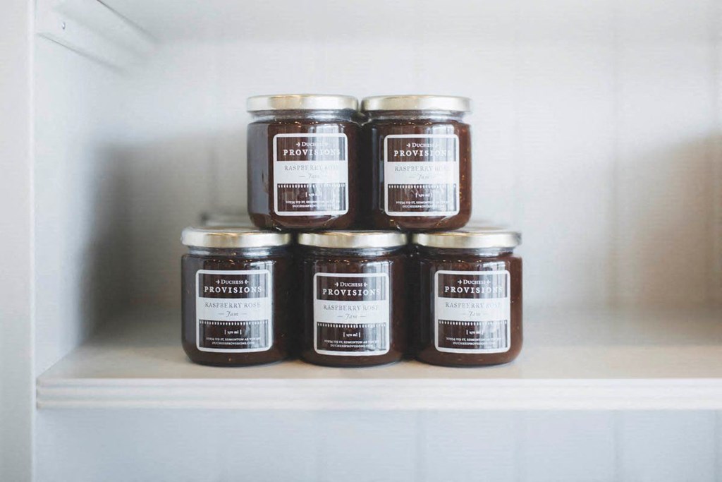 six jars of honey on a shelf in a refrigerator