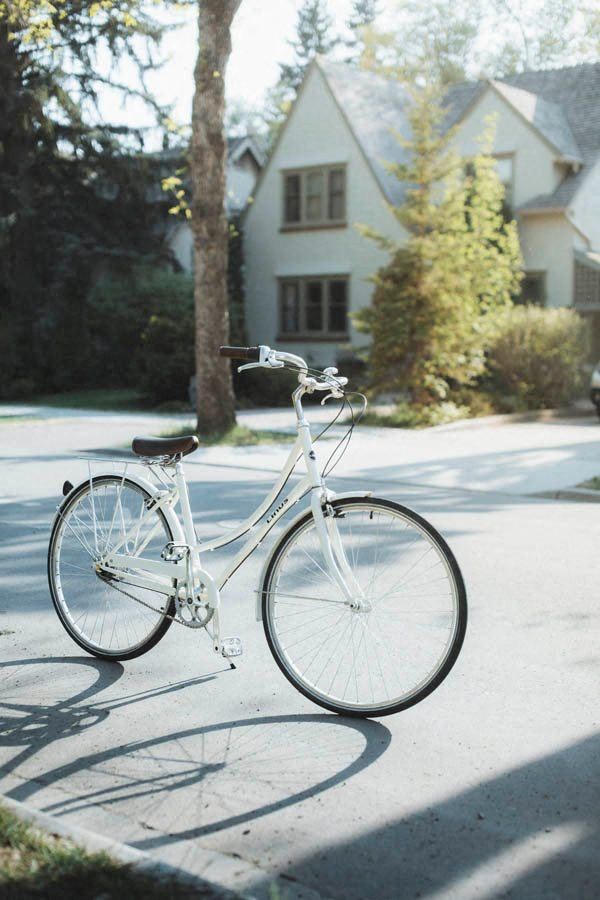 a white bike parked on the side of a street