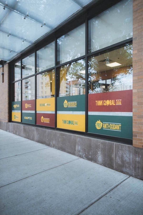 a wall of windows with signs on it on a sidewalk