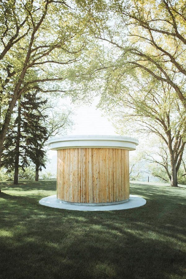 a round building in the middle of a field with trees