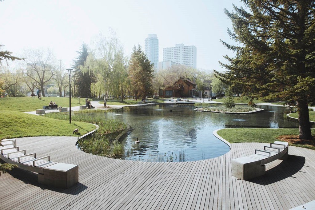 a park with a pond and trees and benches