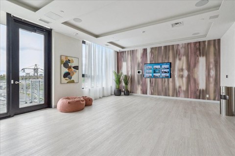 A modern room with a TV on the wall and a view of a power line tower outside the window.