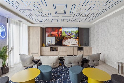 A modern living room with a large screen TV and comfortable seating.