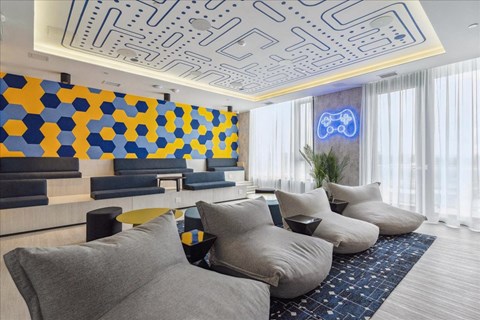 A modern living room with a blue and yellow geometric wall design.