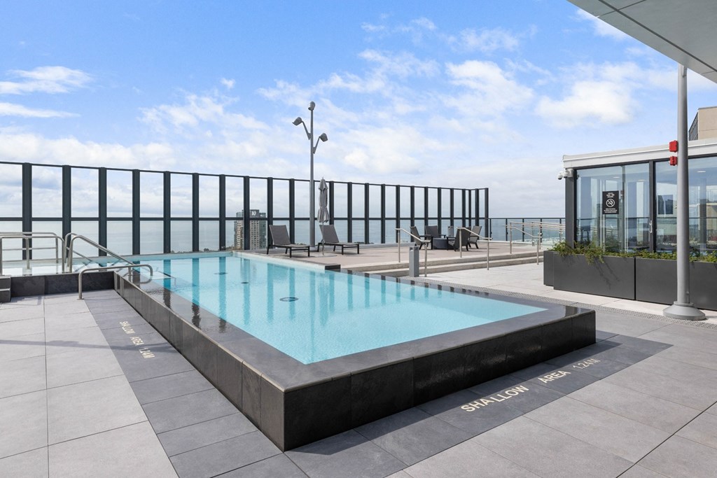 a swimming pool on the rooftop of a building overlooking the ocean