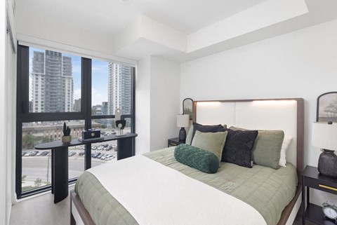 a bedroom with a bed and a large window