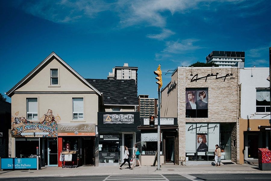 people walking on a city street with buildings