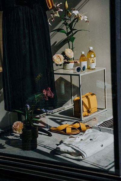 a table with a pair of shoes and a vase with flowers