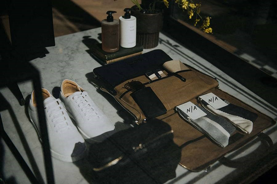 a table with a pair of white shoes and a bag