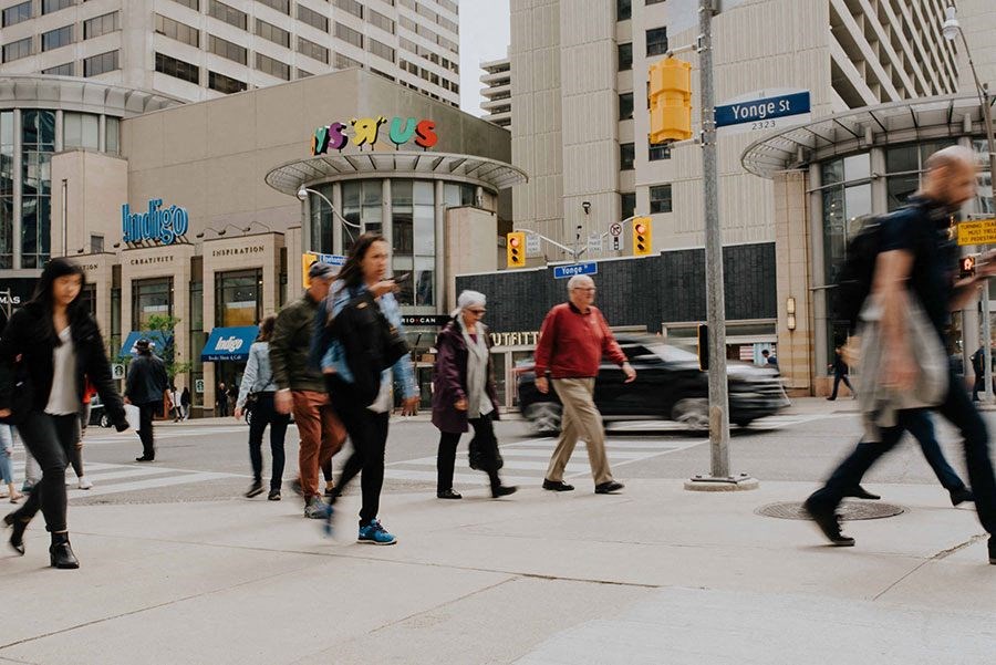 a group of people crossing a busy city street